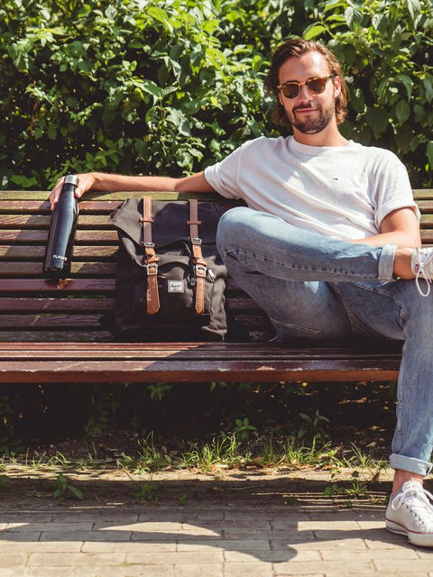 Man on a bench with his FLASKE bottle