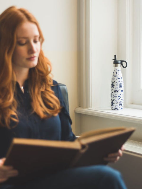 Woman reading next to her FLASKE bottle