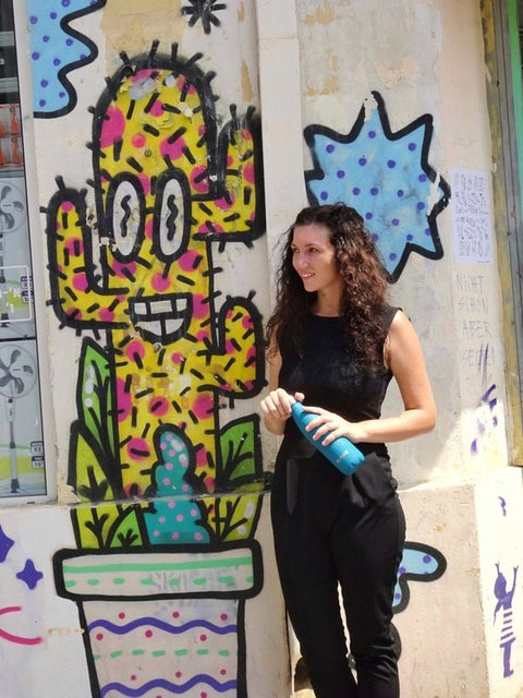 Woman by a graffiti wall with her FLASKE