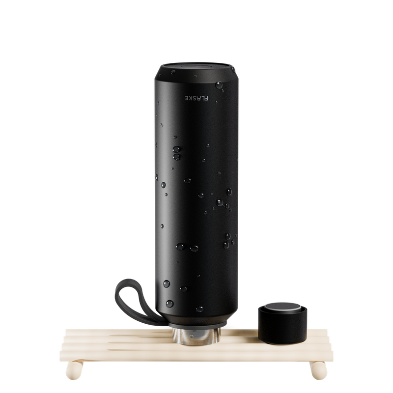 FLASKE EVO bottle drying upside down on a wooden rack, lid off